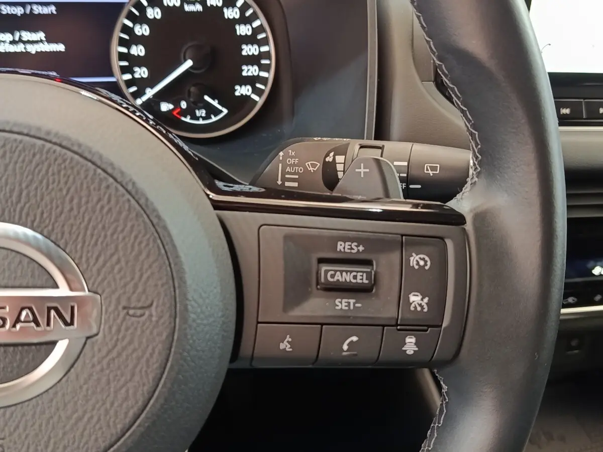 Gros plan sur le volant cuir du Nissan Qashqai 2022, côté droit avec commandes de régulateur et assistance conduite.