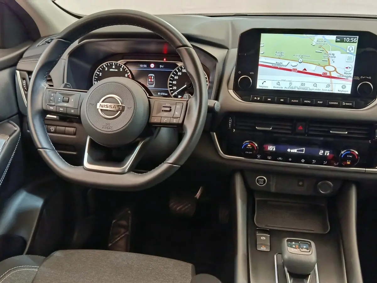 Vue intérieure du tableau de bord du Nissan Qashqai 2022, avec volant cuir, écran tactile et navigation affichée.