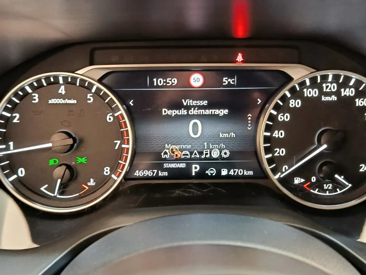Tableau de bord du Nissan Qashqai 2022, affichage numérique central avec compte-tours et vitesse en km/h, éclairage vert allumé.