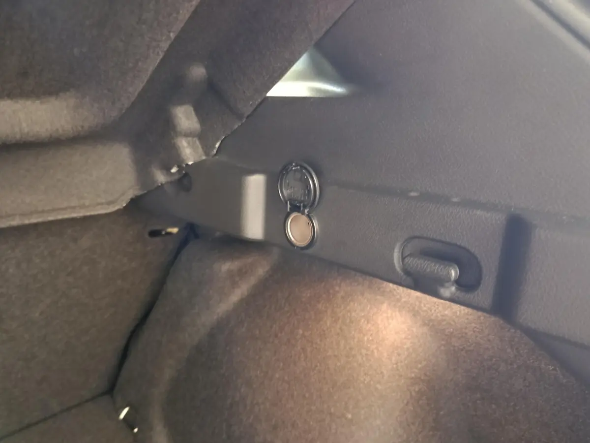 Détail du coffre du Nissan Qashqai gris foncé 2022 avec prise 12V et éclairage intérieur visible.