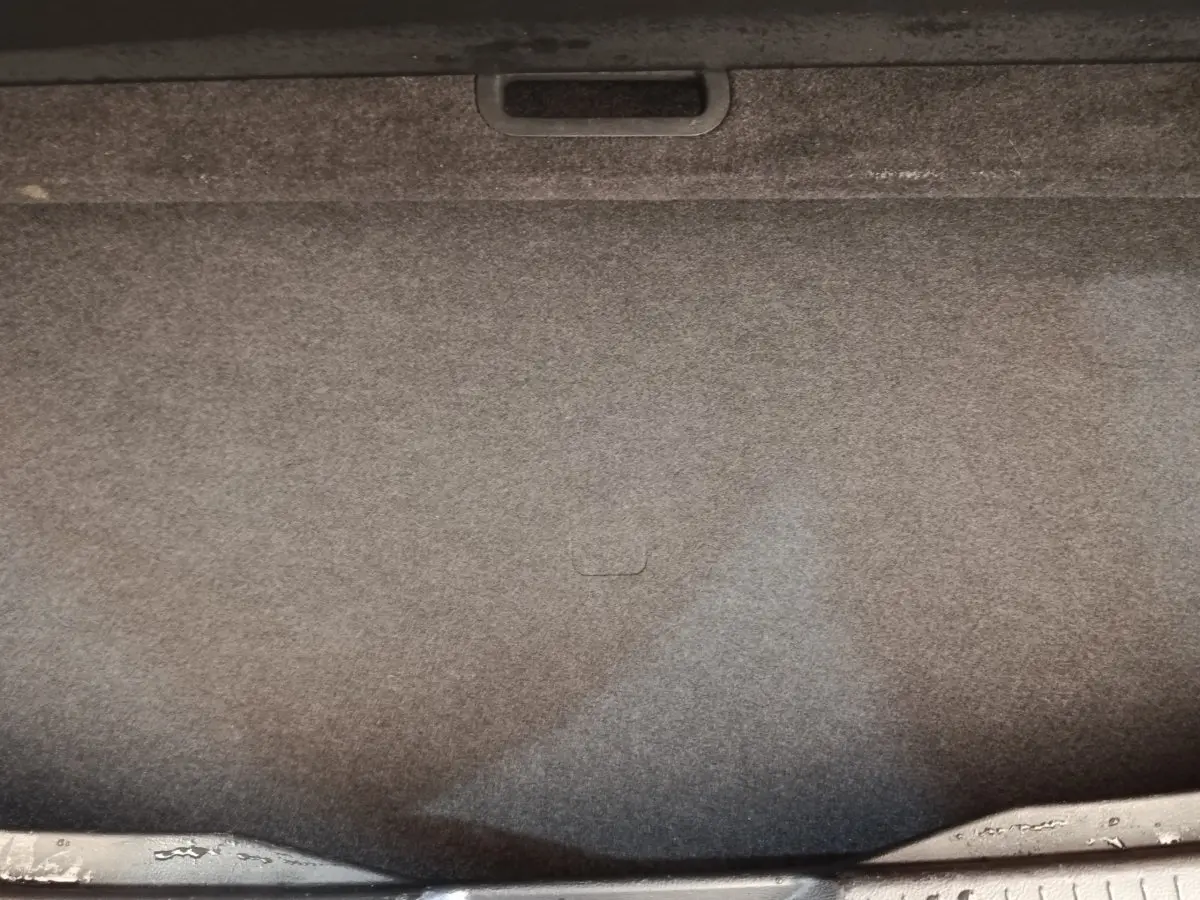 Vue intérieure du coffre spacieux du Nissan Qashqai 1.3 MHEV gris foncé, avec revêtement en tissu gris.