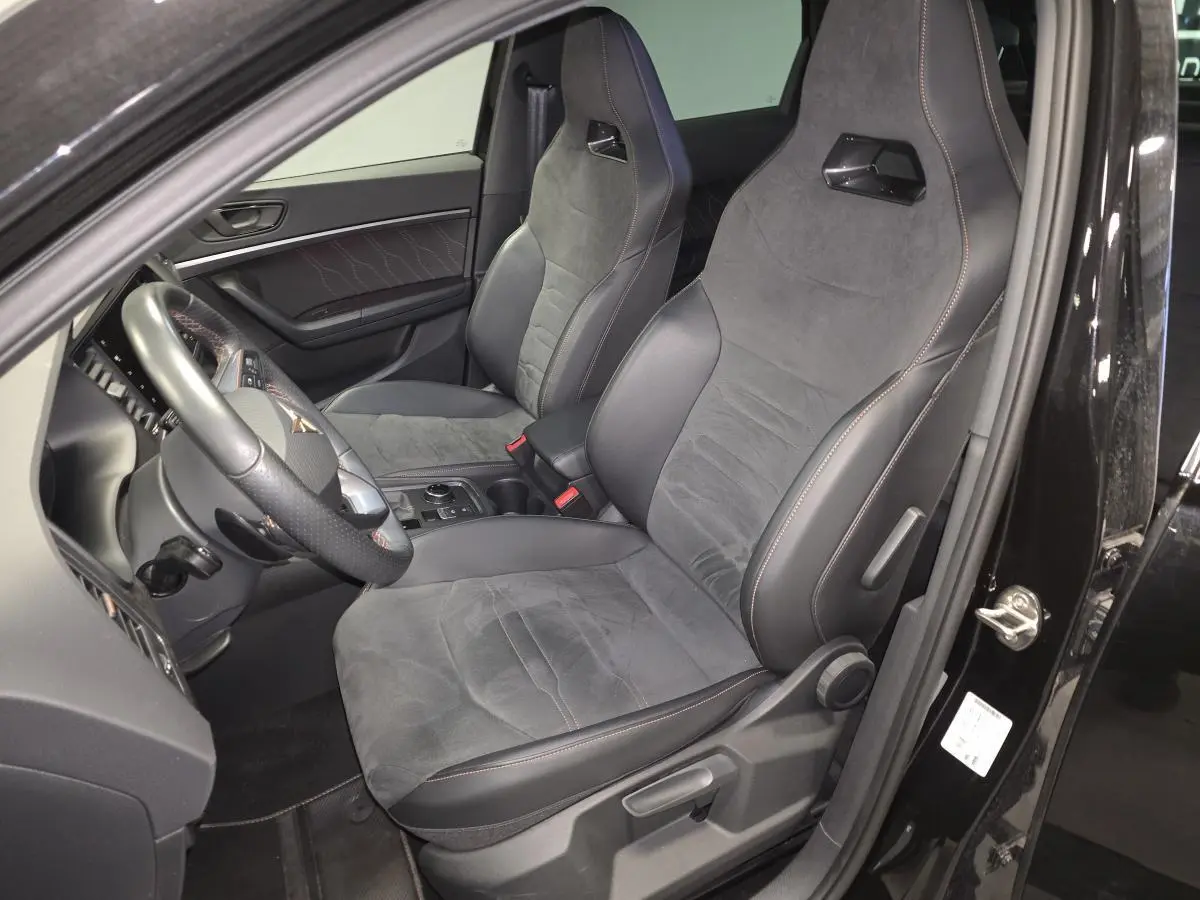 Vue intérieure côté conducteur du CUPRA Ateca 2024 noir, sièges baquets en suédine noire avec surpiqûres copper.