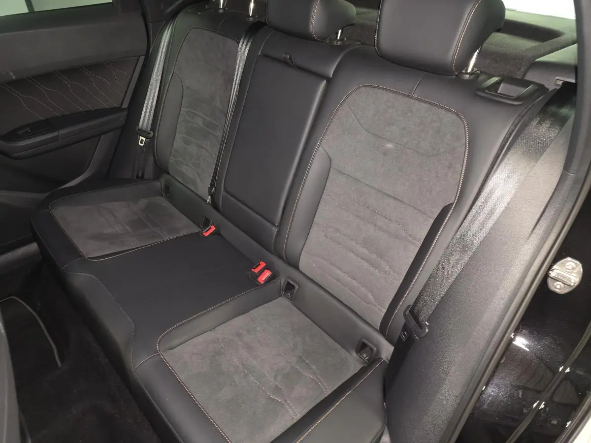 Vue intérieure des sièges arrière en suédine noire avec surpiqûres copper du CUPRA Ateca 2024, porte ouverte côté droit.