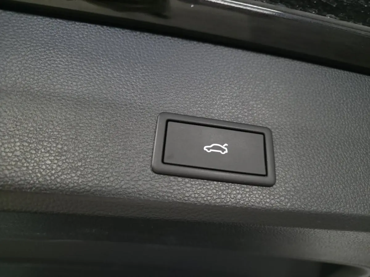 Bouton noir d'ouverture électrique du hayon sur panneau intérieur d'un CUPRA Ateca 2024, finition noire.