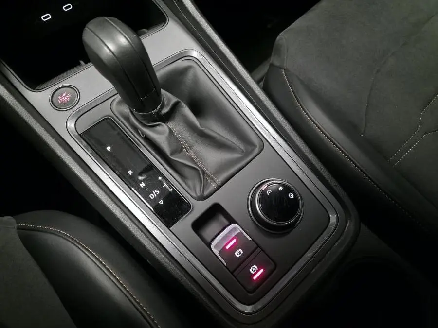 Vue rapprochée de la console centrale noire du CUPRA Ateca 2024 avec levier de vitesse automatique et molette de sélection.