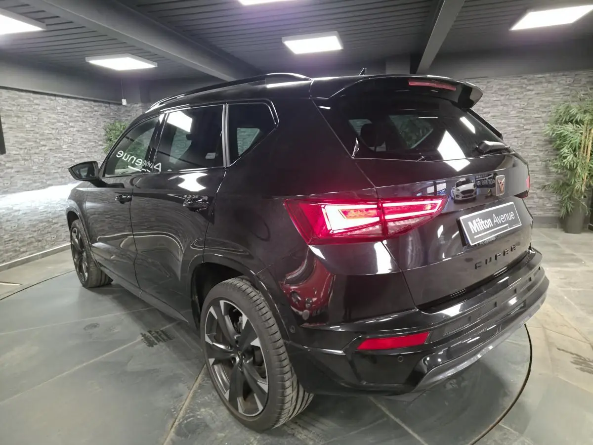 Vue 3/4 arrière droite d’un CUPRA Ateca noir avec feux LED et jantes alliage 19 pouces dans un showroom.