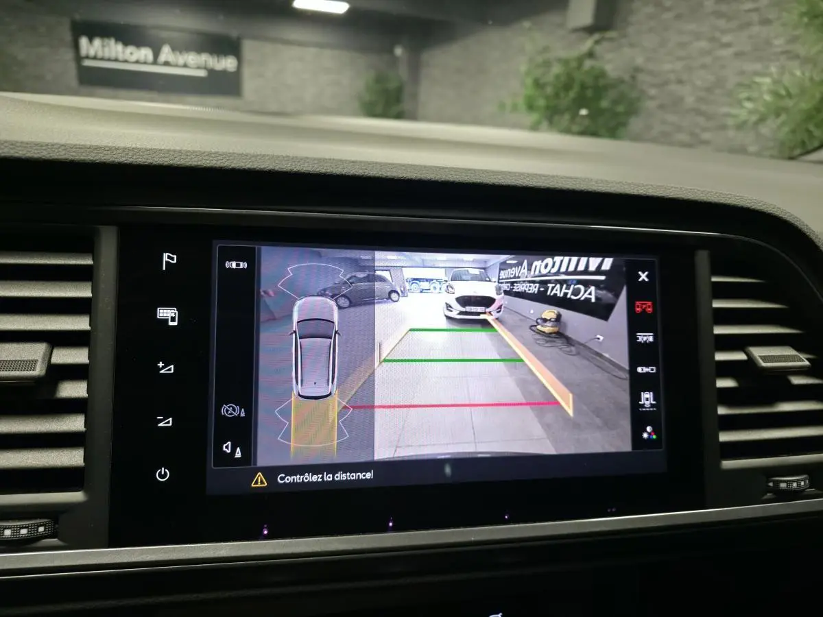 Écran de caméra de recul montrant l’arrière d’une CUPRA Ateca noire avec lignes de guidage colorées.