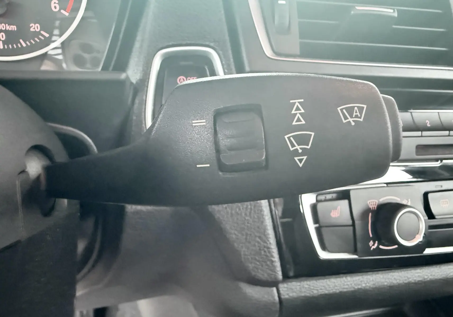 Gros plan sur la commande d’essuie-glace du tableau de bord intérieur d’une BMW Série 1 noire de 2016.
