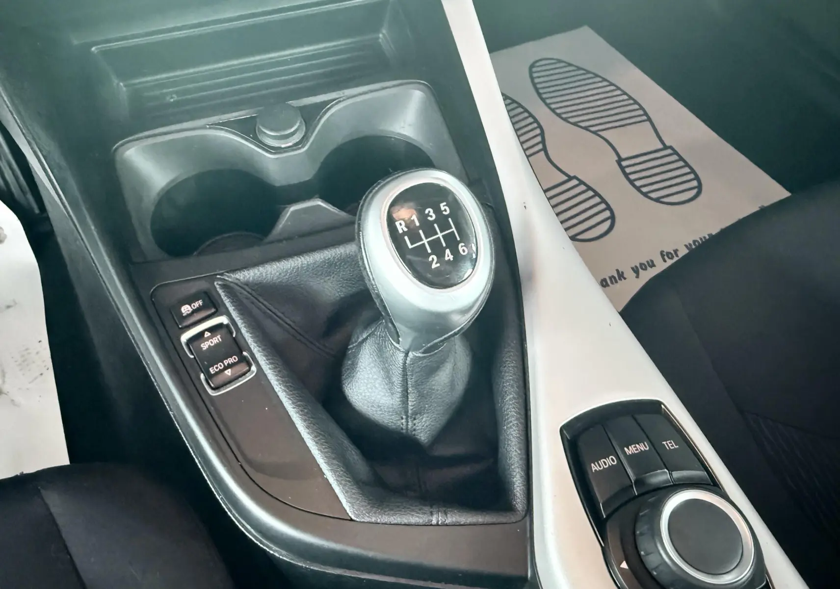 Gros plan sur la boîte manuelle et la console centrale noire et blanche de la BMW Série 1 2016.