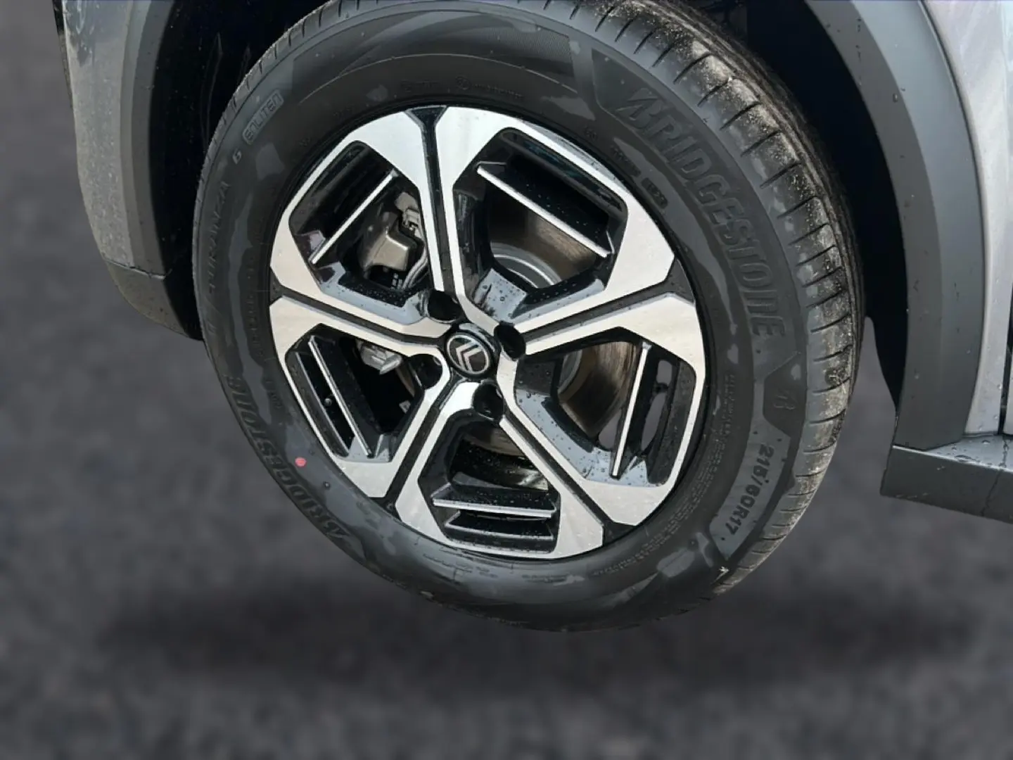 Gros plan sur la roue avant droite avec jante alu noire et argentée du Citroën C3 Aircross gris mercury.