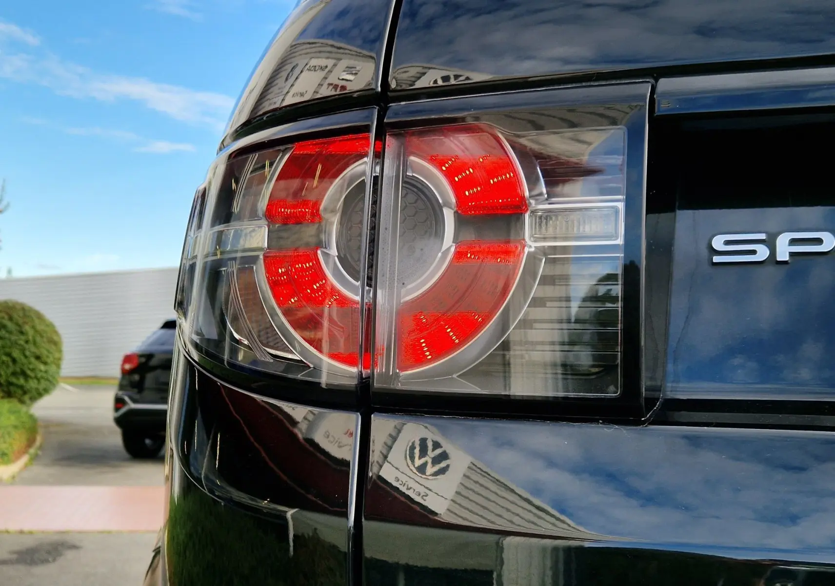 Gros plan sur les commandes multifonctions noires et argentées du volant du Land Rover Discovery Sport Mark II noir de 2017.