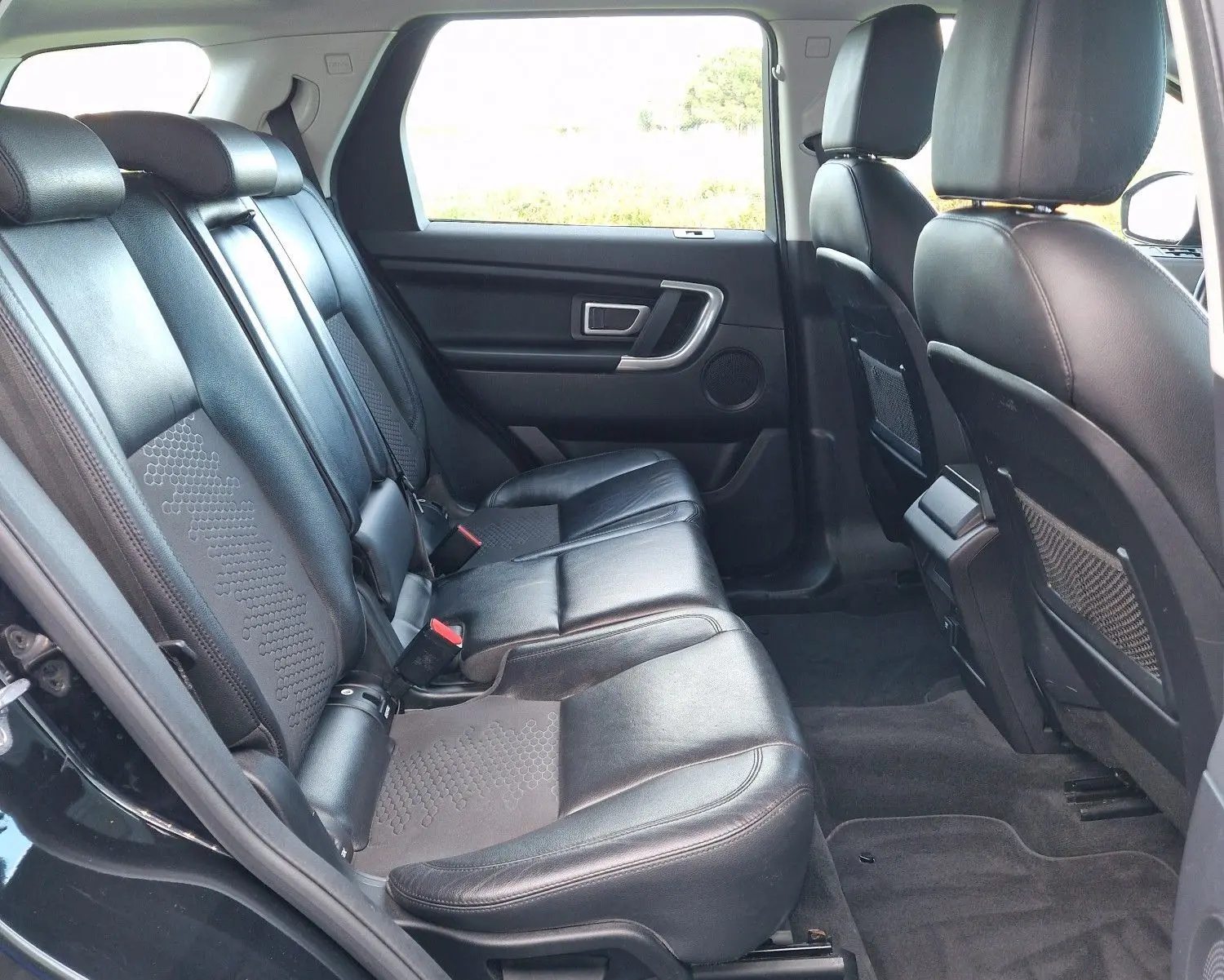 Vue 3/4 arrière droite d'un Land Rover Discovery Sport noir de 2017, avec logo distinctif et finition SE A visible.