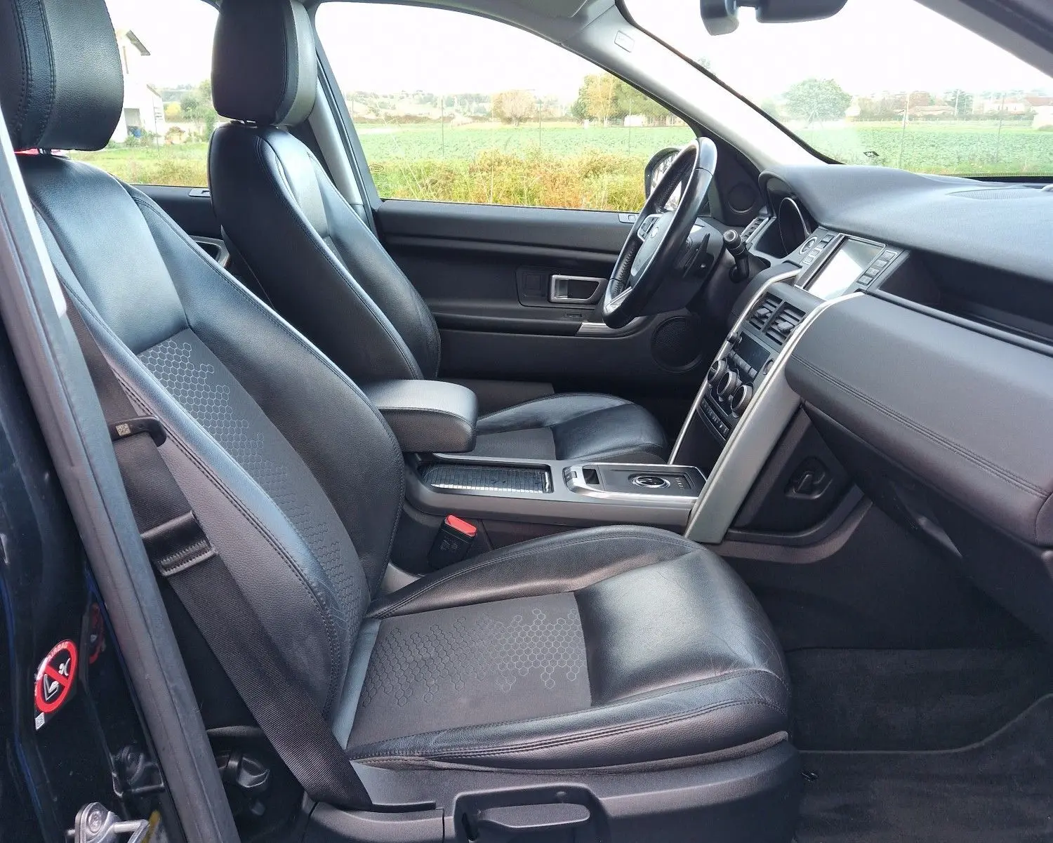 Commandes des vitres électriques et réglage des rétroviseurs sur la porte intérieure d'un Land Rover Discovery Sport Mark II noir de 2017