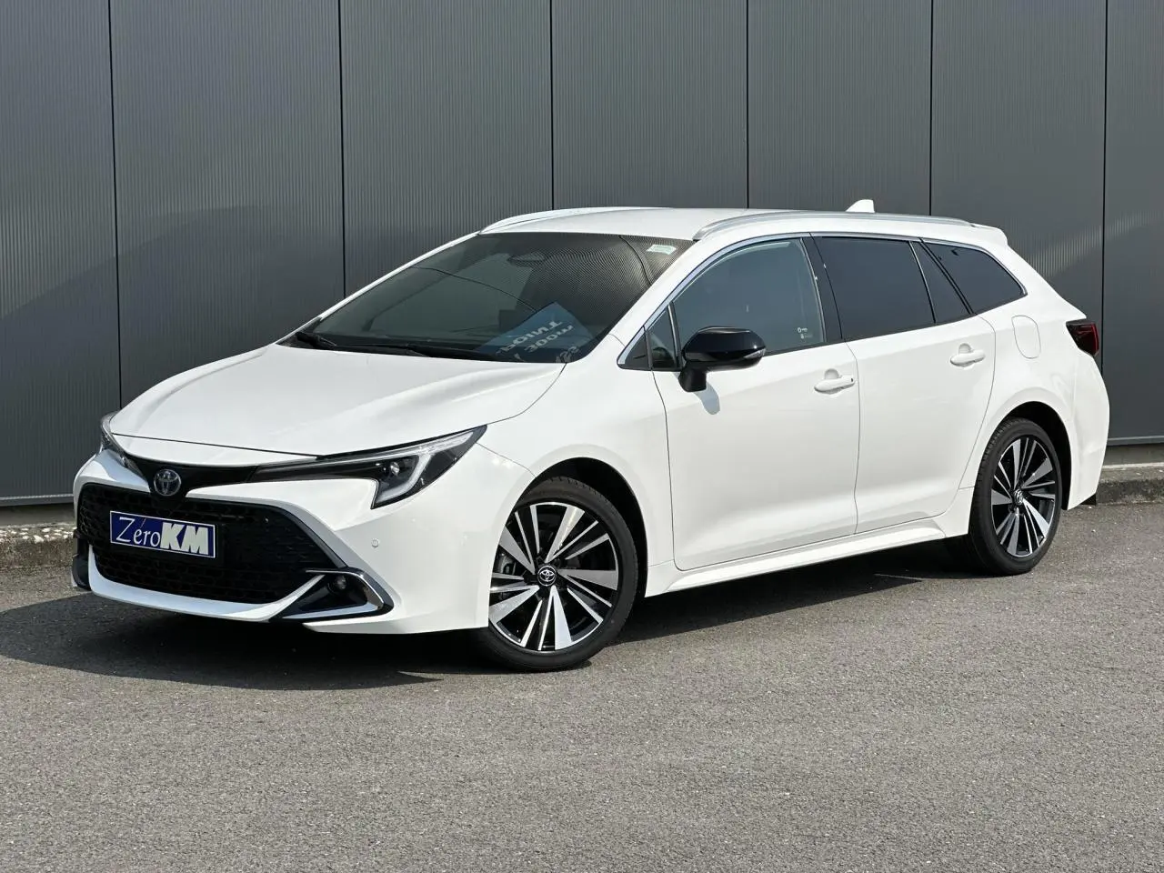 Toyota Corolla Touring Sport blanc neige vue 3/4 avant droit avec jantes alliage diamantées et vitres teintées