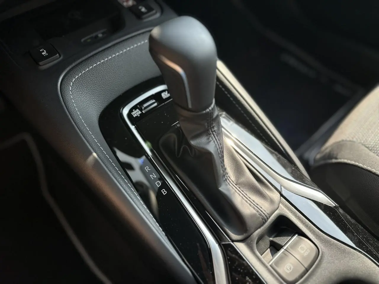 Le levier de vitesses automatique noir de la Toyota Corolla Touring Sport 1.8 Hybrid 2025 vu en gros plan côté conducteur.