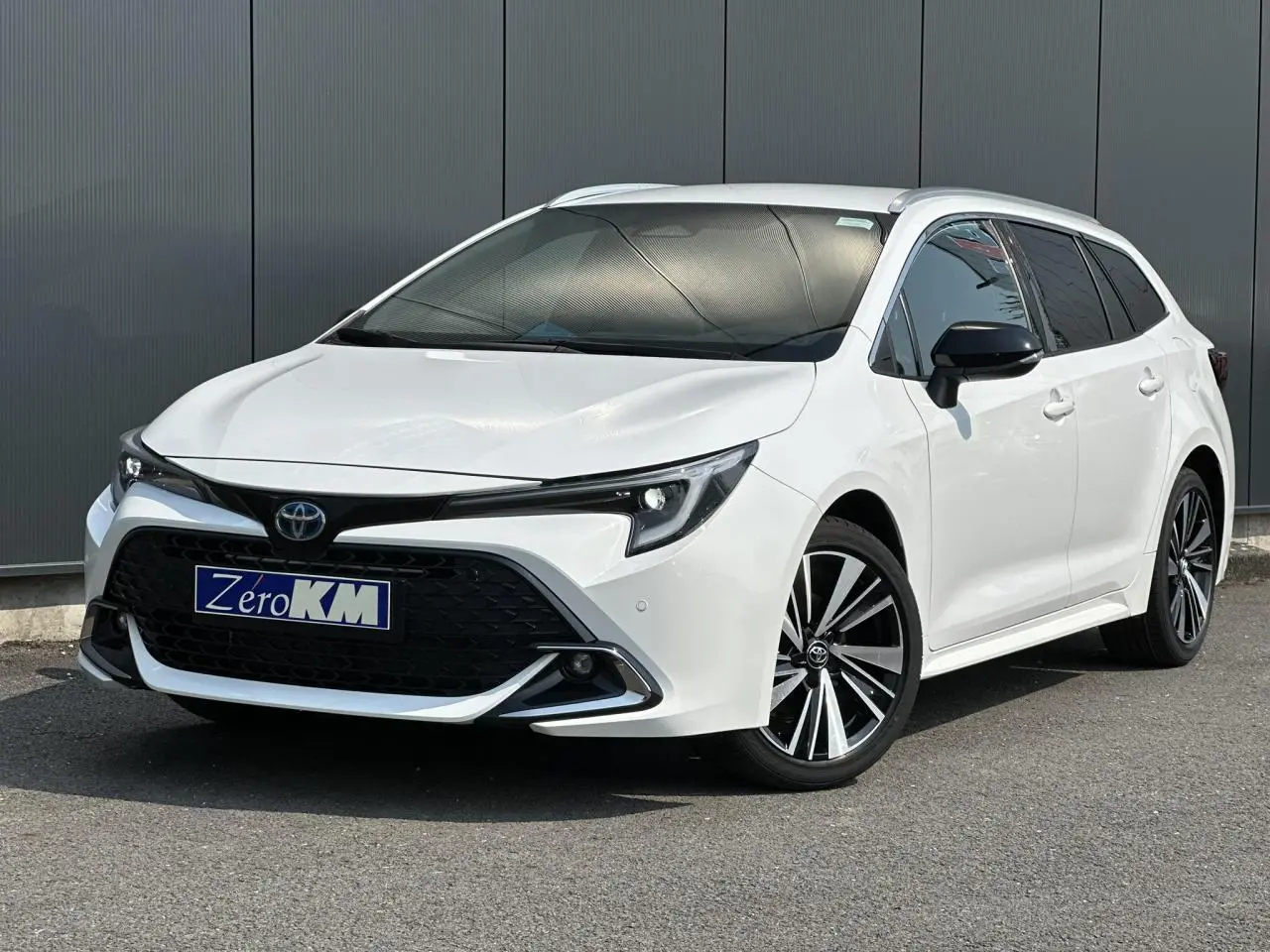 Toyota Corolla Touring Sport blanc Neige en 3/4 avant droit avec jantes alliage 17'' et vitres teintées.