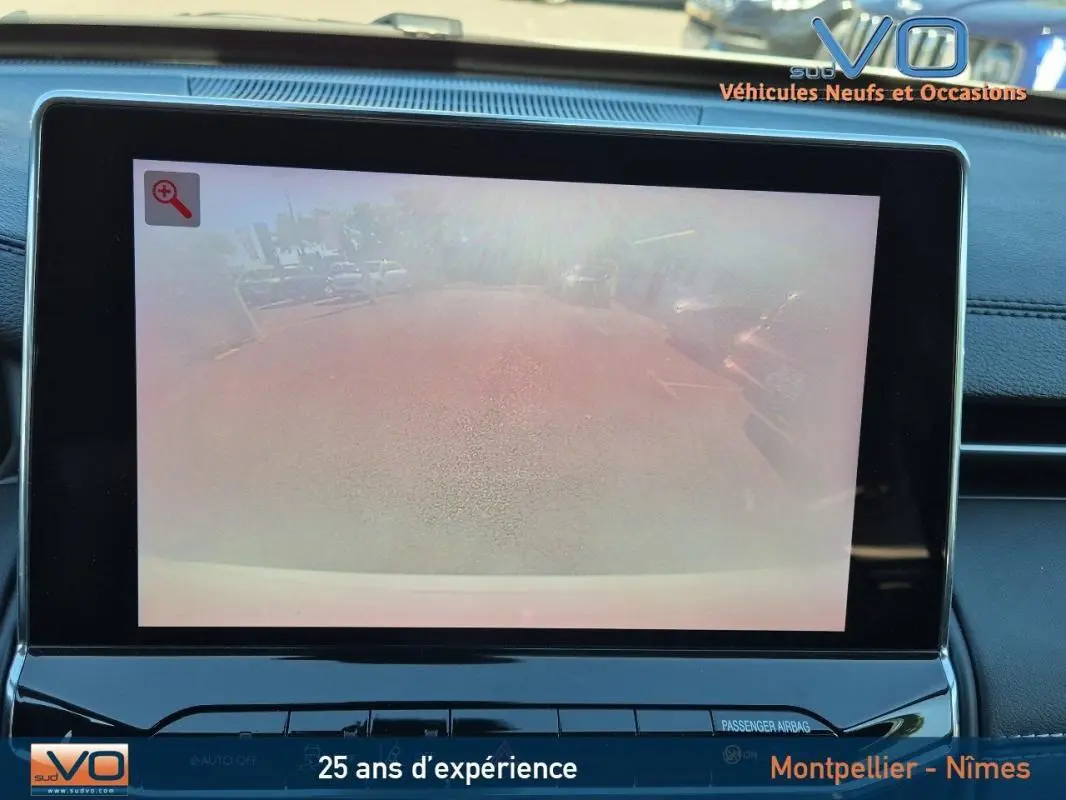 Écran tactile intérieur du Jeep Compass 2023 affichant la caméra de recul avec vue arrière floutée.