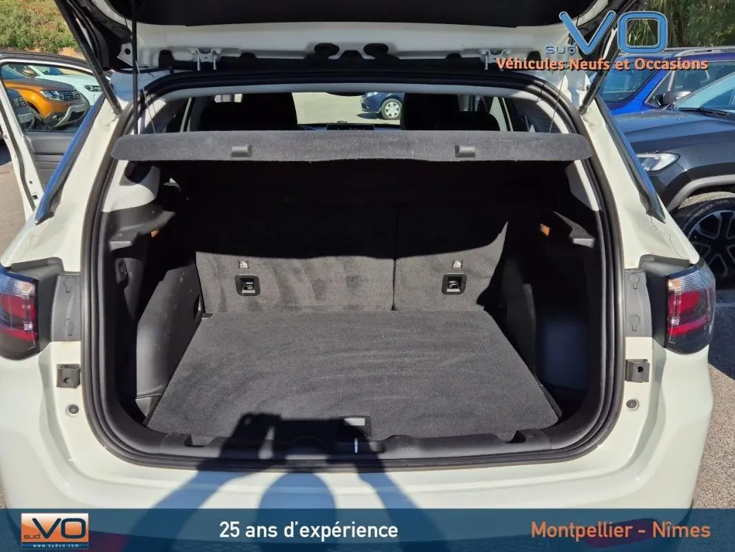 Coffre ouvert vu de l'arrière d'un Jeep Compass blanc 2023, montrant l'espace de chargement vide et la plage arrière.