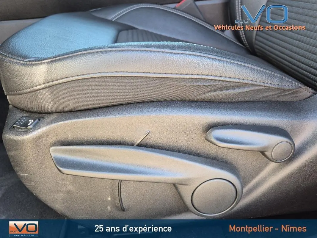 Gros plan sur les commandes de réglage manuel du siège conducteur en cuir noir du Jeep Compass blanc 2023.