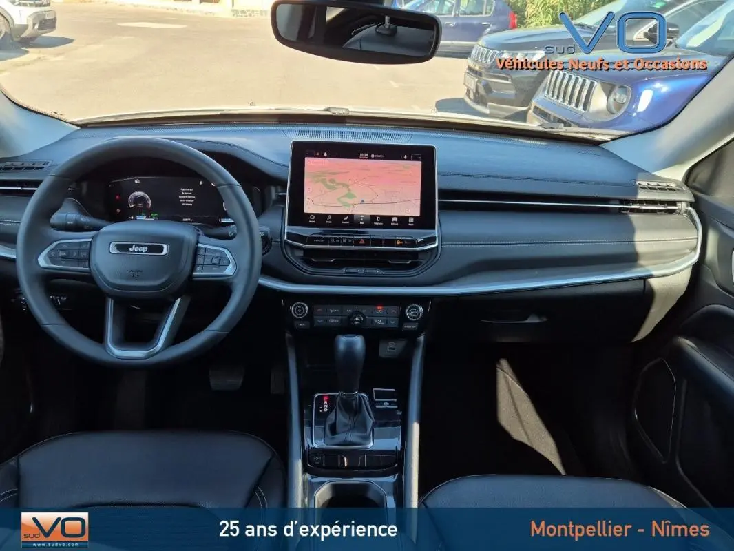 Tableau de bord et console centrale du Jeep Compass blanc 2023, avec écran tactile et volant multifonction.