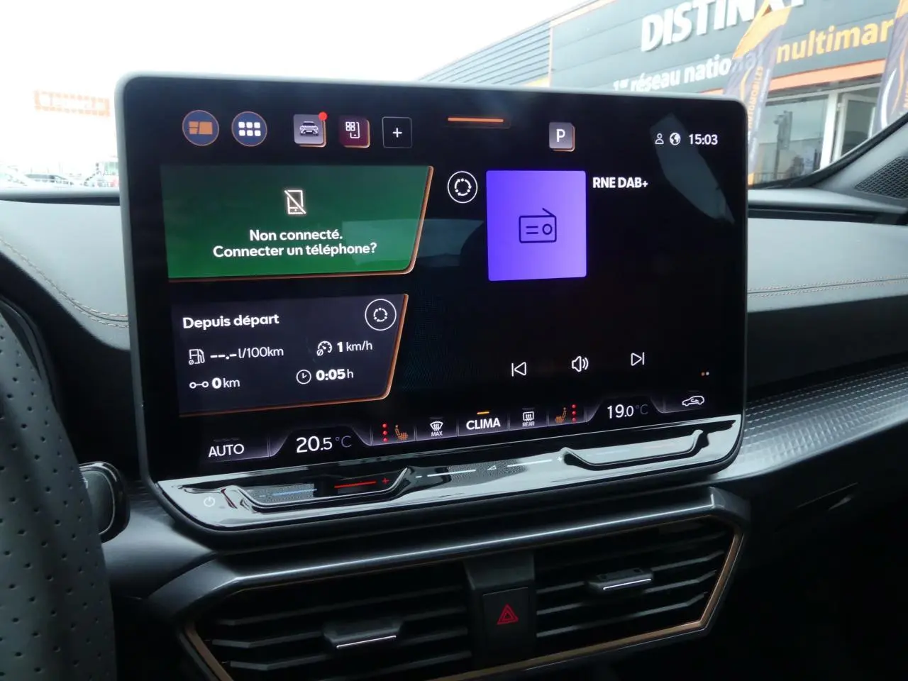 Écran tactile central du tableau de bord du CUPRA Formentor gris Graphène, affichant la radio et la climatisation.