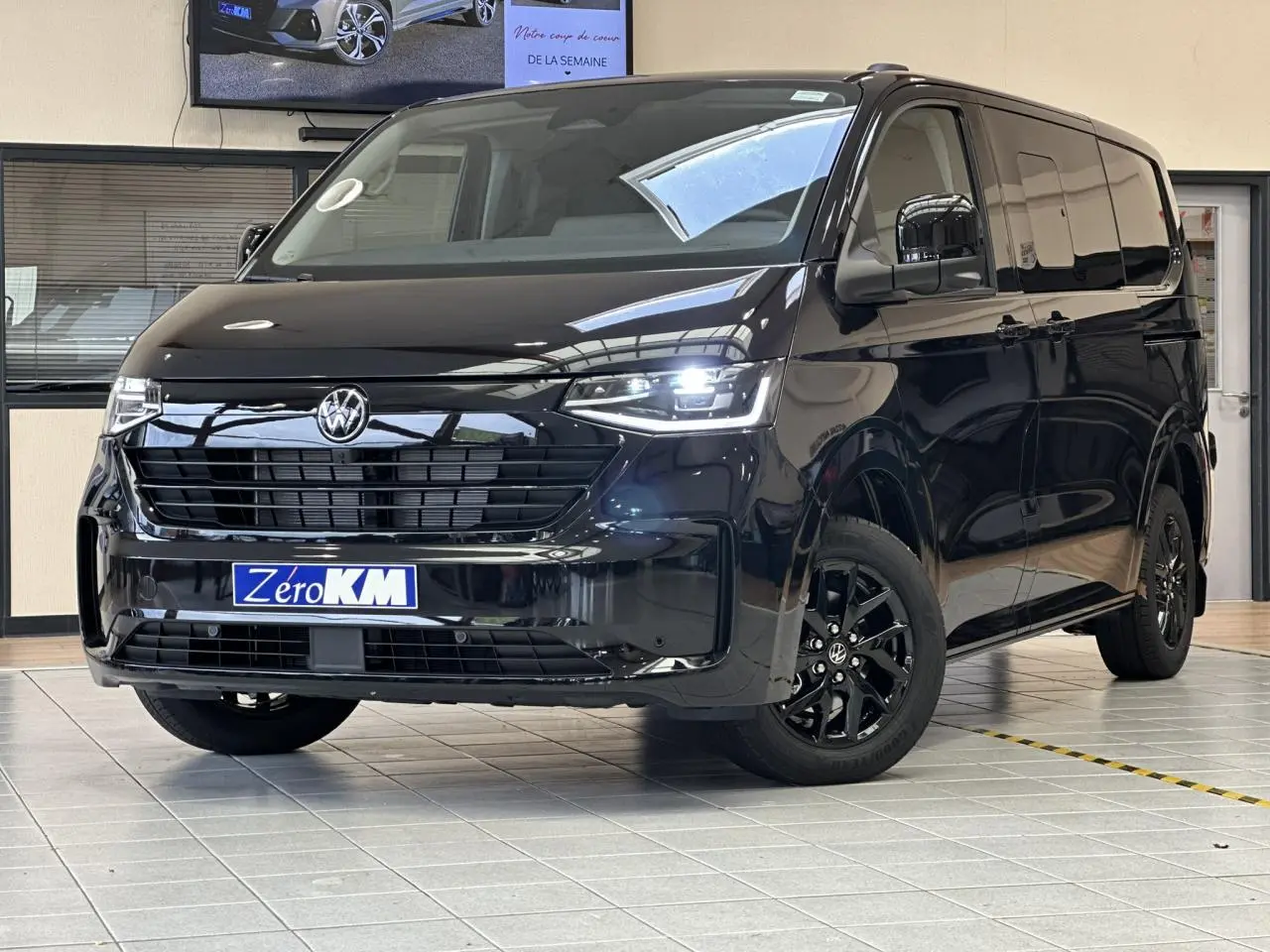 Volkswagen Transporter T7 ProCab noir Minuit, vue 3/4 avant droit avec jantes alliage noir brillant et feux LED allumés.