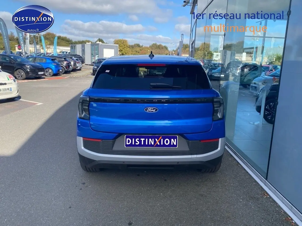 Vue arrière du Ford Explorer électrique 2025 en bleu Premium My Mind métallisé, avec feux arrière LED et lunette arrière surteintée.