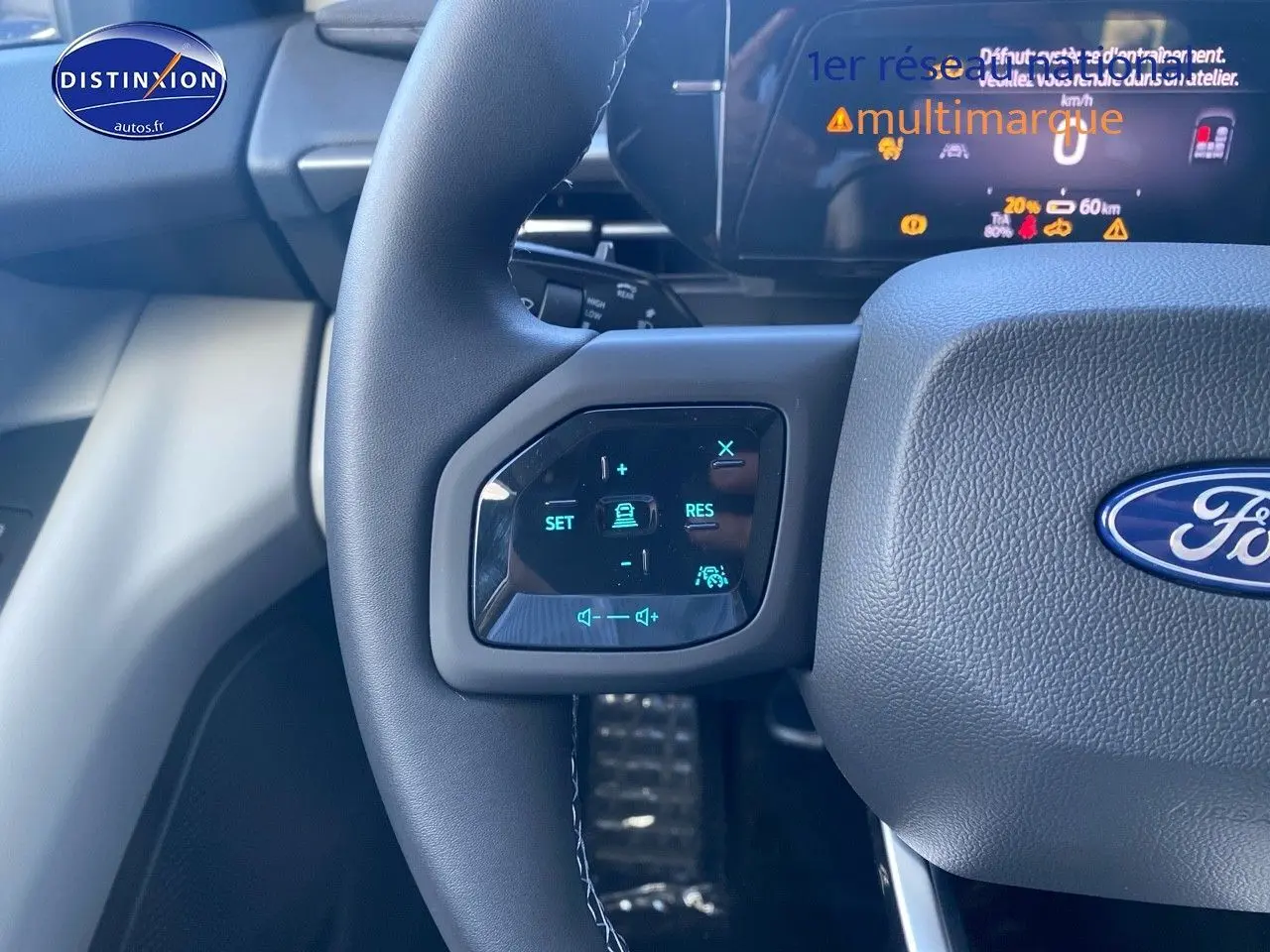 Gros plan sur le volant multifonction du Ford Explorer 2025, boutons de contrôle de conduite assistée et audio visibles.
