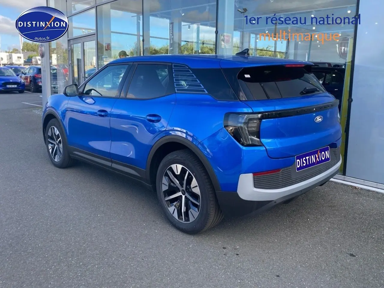 Vue 3/4 arrière droite du Ford Explorer électrique 2025 en bleu métallisé Premium My Mind, avec feux arrière LED et jantes stylées.
