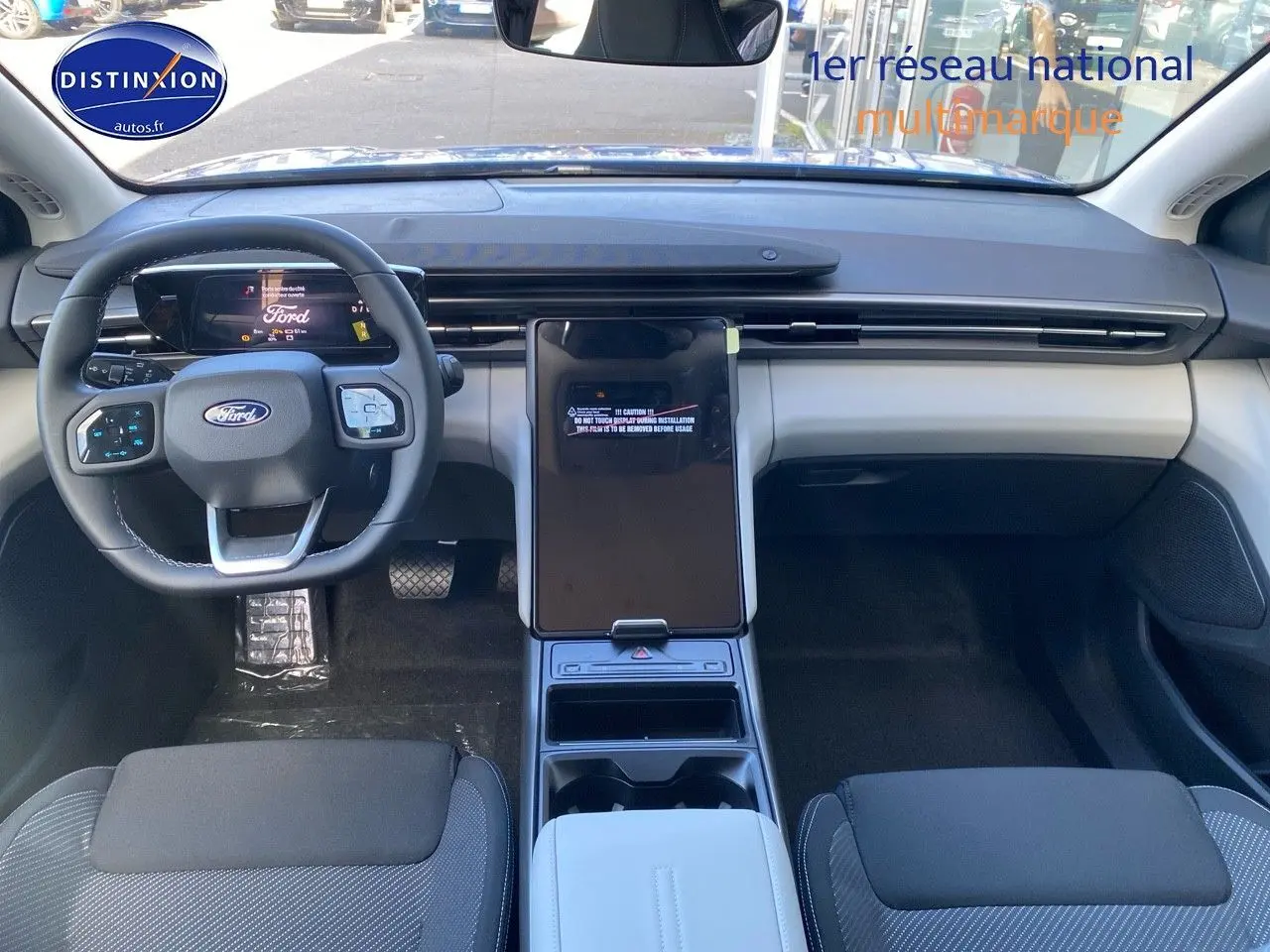 Vue intérieure avant du Ford Explorer 2025 avec tableau de bord moderne et écran tactile central vertical.