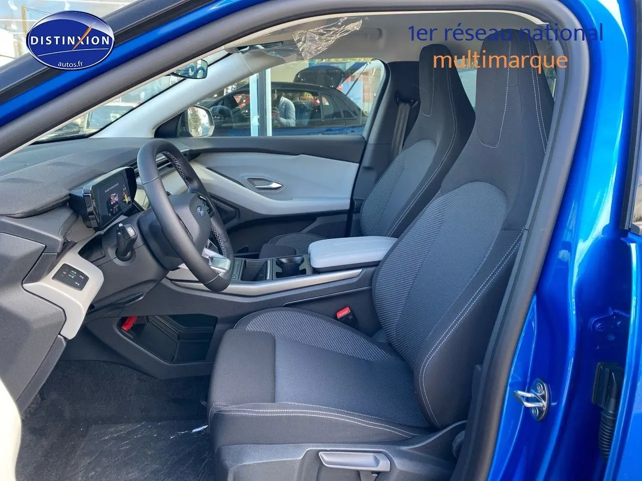 Vue intérieure côté conducteur du Ford Explorer 2025 en bleu métallisé, avec sièges sport noirs et tableau de bord moderne.