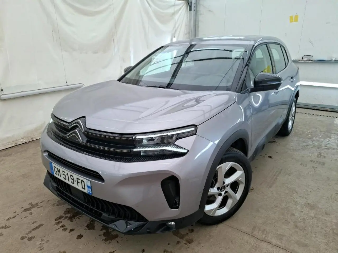 Citroën C5 Aircross gris Artense en 3/4 avant droit, avec calandre noire brillante et jantes alliage 18 pouces.