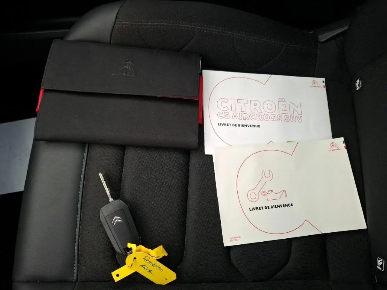 Vue rapprochée du siège avant noir du Citroën C5 Aircross avec clé et livrets d'accueil posés dessus.