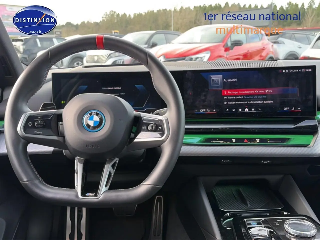 Vue intérieure centrée sur le volant cuir noir et l'écran tactile large du tableau de bord d'une BMW Série 5 i5 M60.