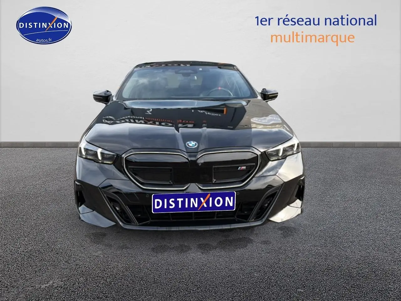 Vue avant d'une BMW Série 5 i5 M60 noire 2024 avec calandre noire et phares LED allumés.