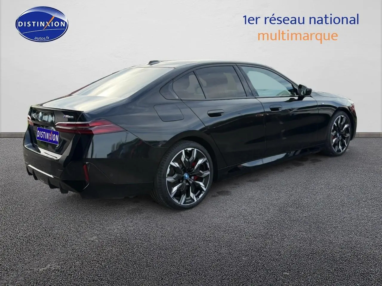 BMW Série 5 i5 M60 noire vue en 3/4 arrière droit, avec jantes alu bicolores et feux arrière LED distinctifs.
