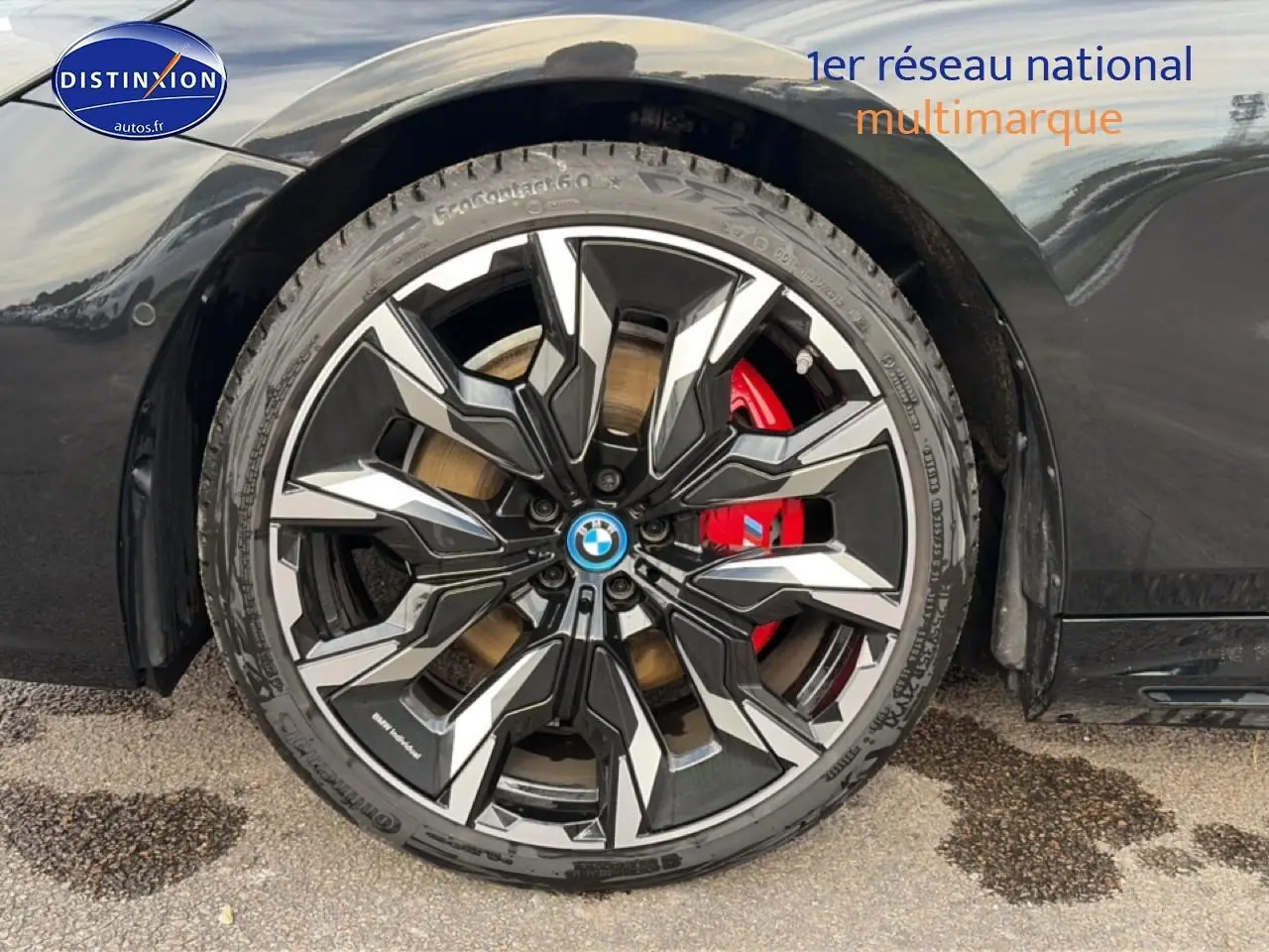 Gros plan sur la roue avant droite noire d'une BMW Série 5 i5 M60 2024 avec étrier de frein rouge visible.