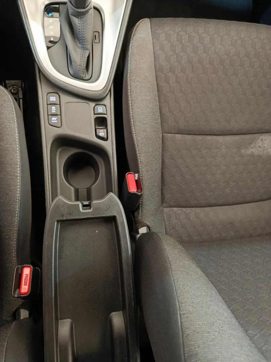 Vue plongeante sur la console centrale et siège avant droit gris foncé de la Toyota Yaris hybride 2022, avec levier de vitesse automatique.