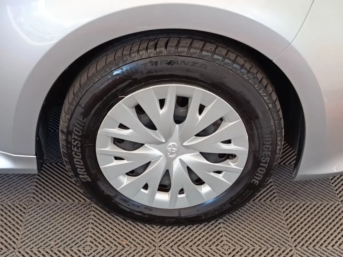 Gros plan sur la roue avant gauche grise claire d'une Toyota Yaris hybride 2022 avec enjoliveur et pneu Bridgestone.