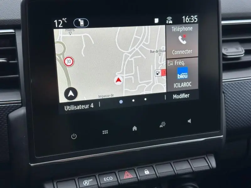 Écran central tactile du Renault Arkana 2025 affichant la navigation et les options téléphone, vue intérieure rapprochée.