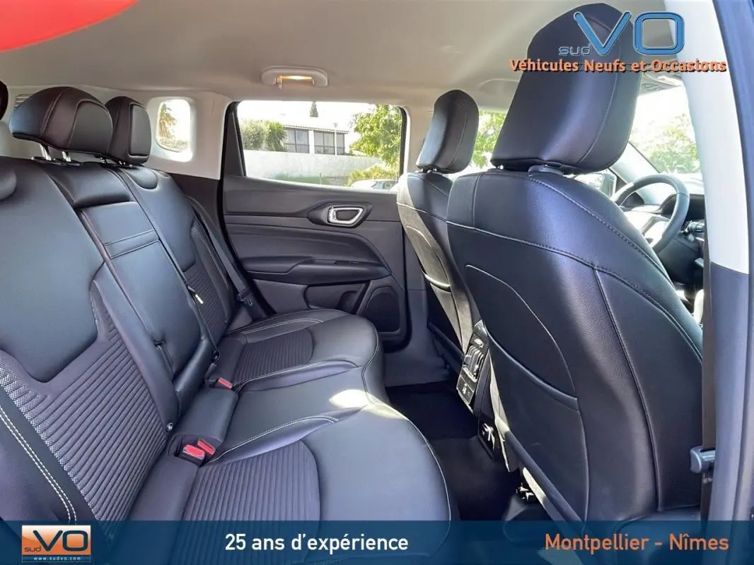 Vue intérieure arrière du Jeep Compass 2023 noir avec sièges cuir noirs et accoudoir central arrière visible