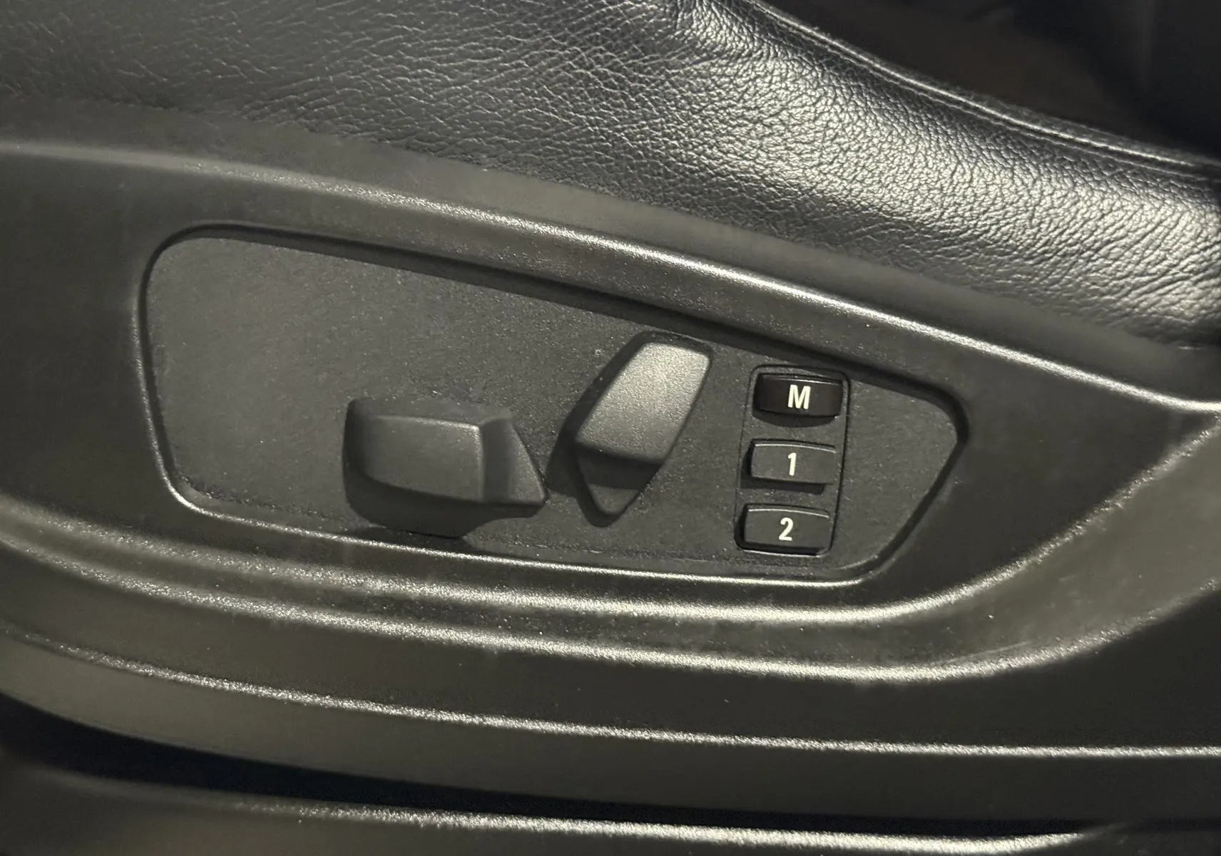Réglages électriques des sièges avec mémoire sur le côté gauche d’un BMW X6 blanc xDrive 40d 2026 M Sport.