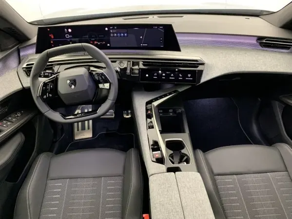Vue intérieure avant du Peugeot 3008 1.2 Hybrid 145 GT avec tableau de bord numérique large et volant cuir multifonctions.