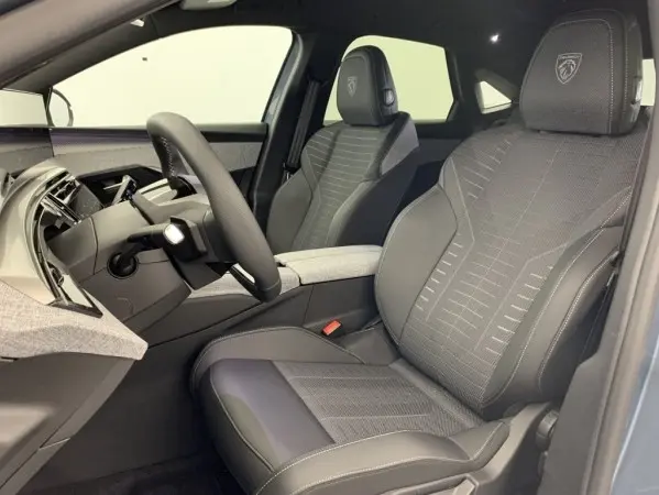 Vue intérieure côté conducteur du Peugeot 3008 1.2 Hybrid 145 GT 2025, sièges en cuir noir avec logo Peugeot brodé.