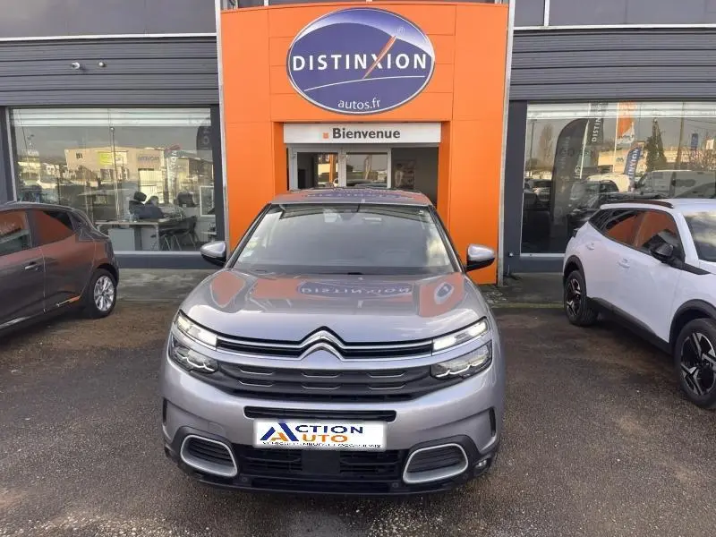 Vue de face d'un Citroën C5 Aircross gris Platinium avec calandre distinctive et phares LED allumés.