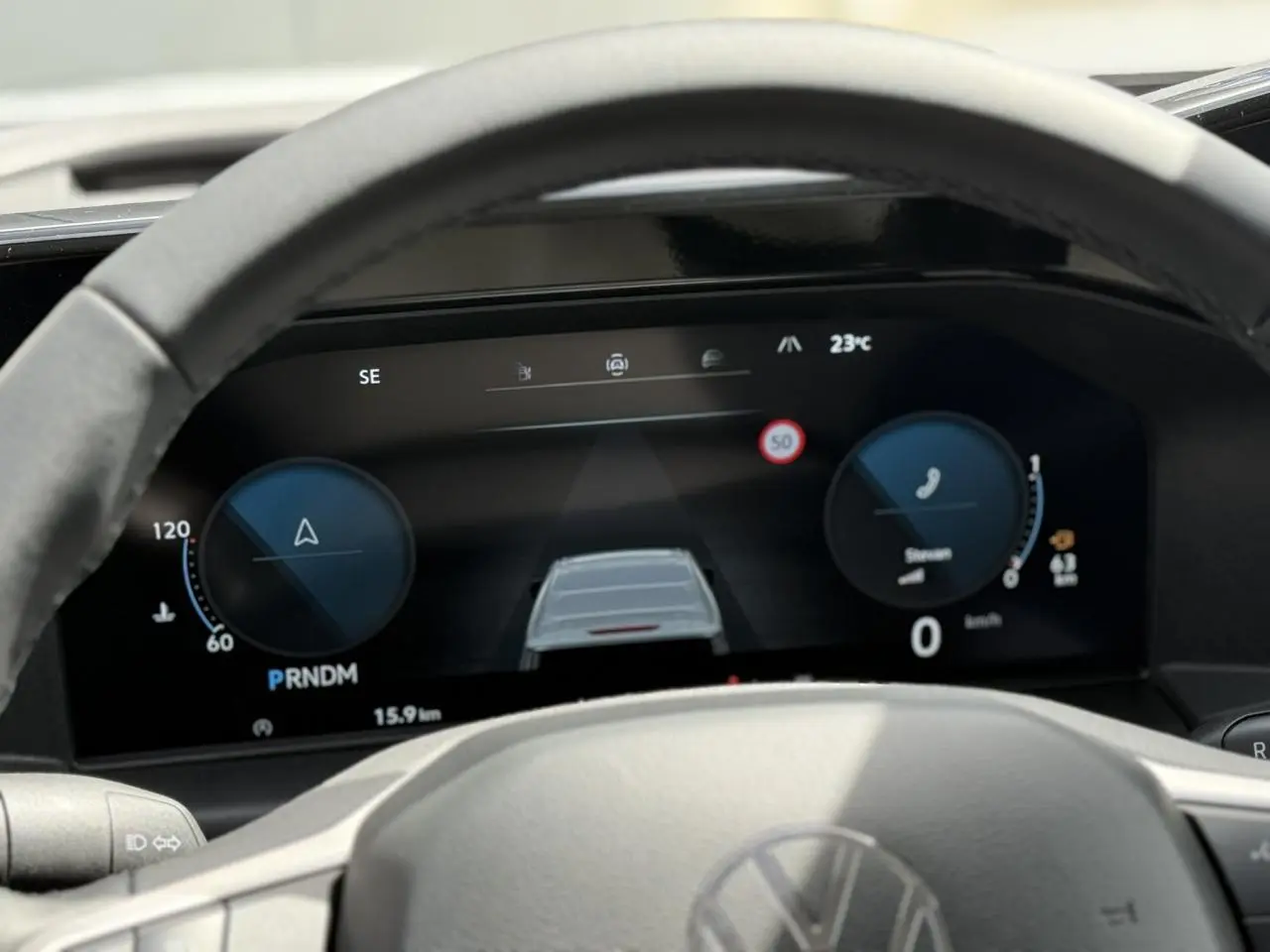 Vue rapprochée du tableau de bord numérique du Volkswagen Transporter T7 gris argent, affichant la vitesse et les aides à la conduite.