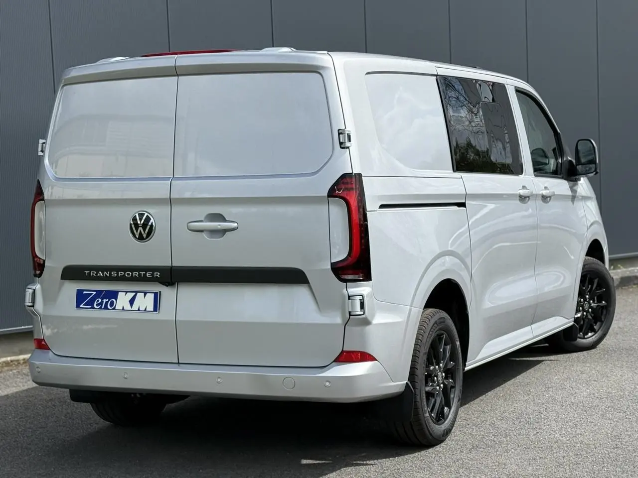 Vue 3/4 arrière droite du Volkswagen Transporter T7 ProCab gris argent avec jantes noires et feux arrière LED signature.