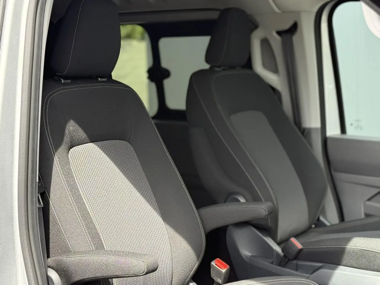 Vue rapprochée des sièges avant en tissu rayé gris du Volkswagen Transporter T7 ProCab L1H1 2026.