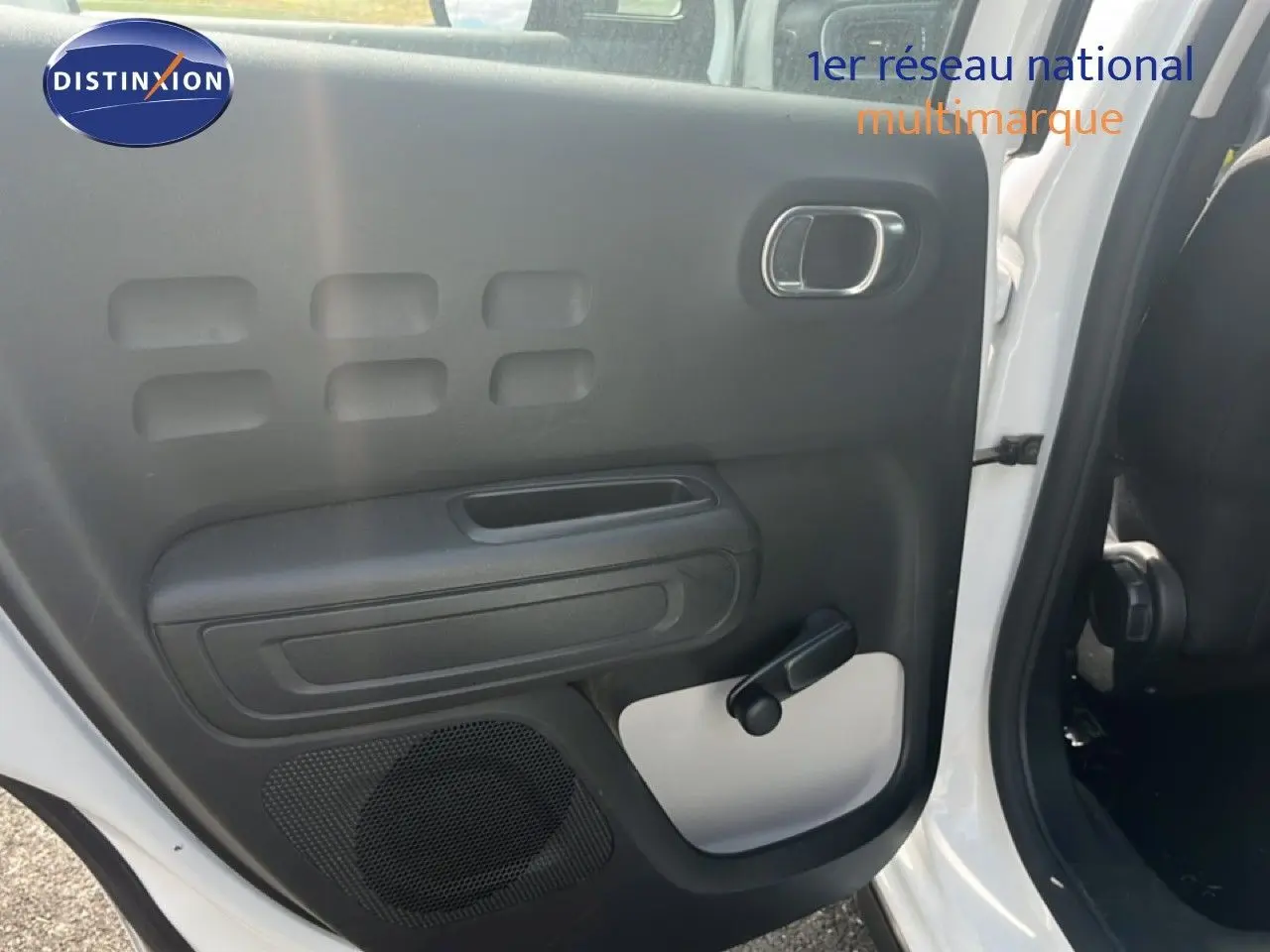 Vue intérieure côté gauche de la porte arrière blanche d'une Citroën C3 2018 avec poignée de fenêtre manuelle.