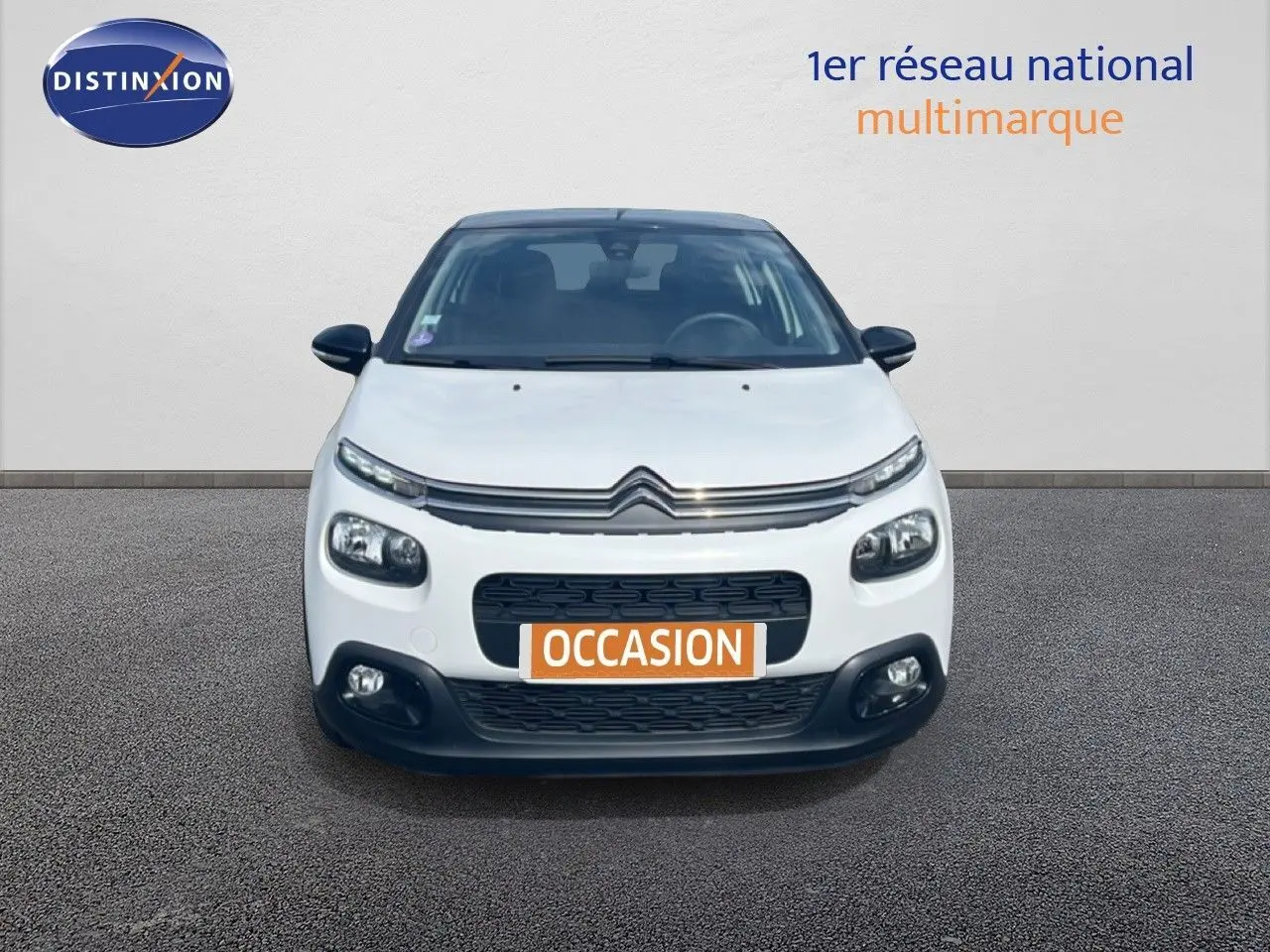 Vue avant d'une Citroën C3 blanche de 2018 avec calandre noire et phares LED, en présentation sur sol gris.